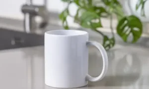 Classic ceramic mugs arranged on wooden kitchen shelf
