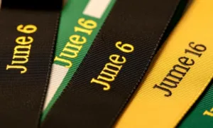 Close-up of a flat polyester lanyard with a printed company logo, laid on a white background